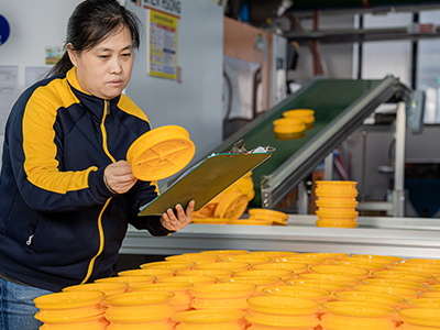 woman inspecting completed pieces using a reference