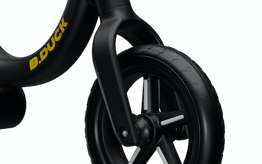 close up view of yellow and black balance bike front wheel