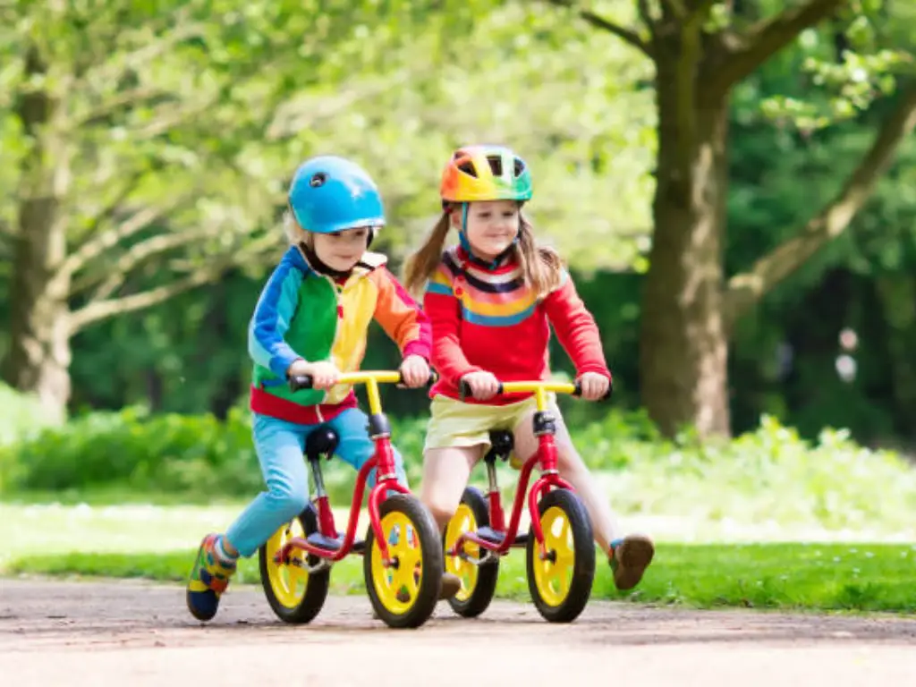 two little girls riding balance bike together